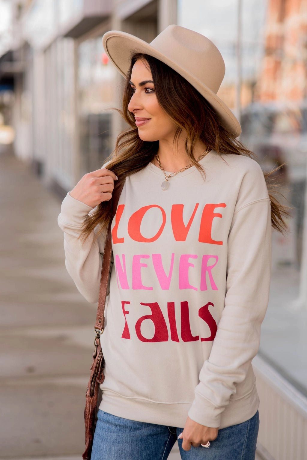 product display bead accents Love Never Fails Graphic Crewneck